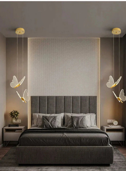 Modern Butterfly LED Pendant Light casting a soft, warm glow in a cozy bedroom—minimalist metal design with gentle ambient lighting for relaxation.