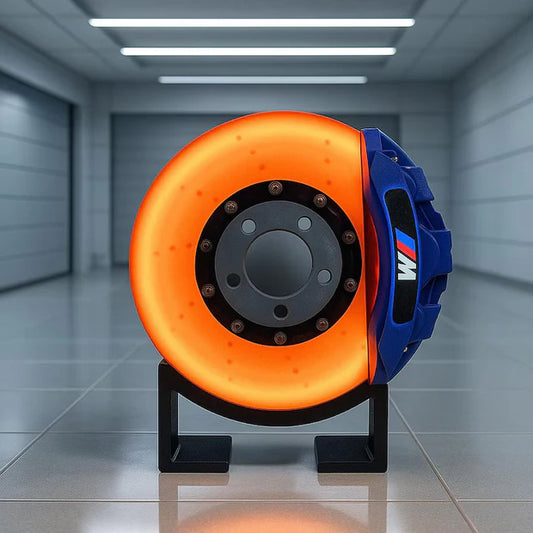 Orange and blue brake disc on a stand in a garage setting