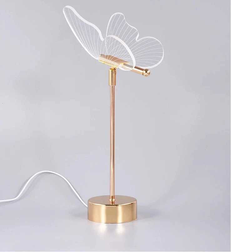 Decorative lamp with gold base and leaf-shaped design on a light gray background