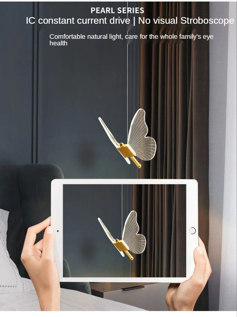 Butterfly decorations on a window with a tablet showing the reflection, against a dark curtain background.