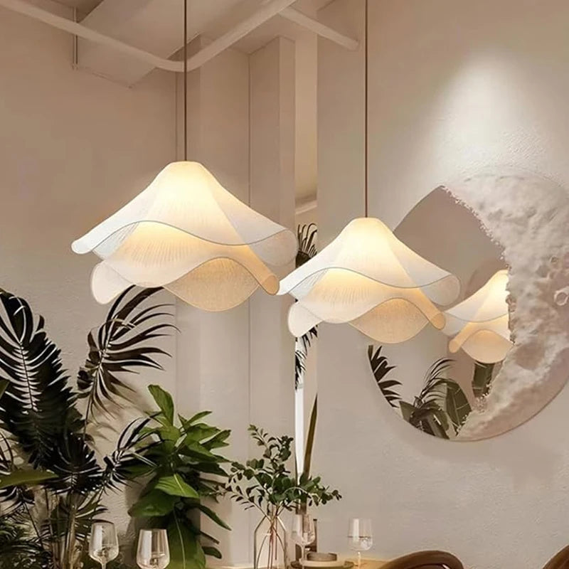 Modern pendant lights hanging in a room with plants and decor.